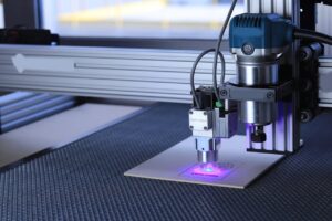 Close-up of a laser cutting machine engraving a design on metal using advanced technology.